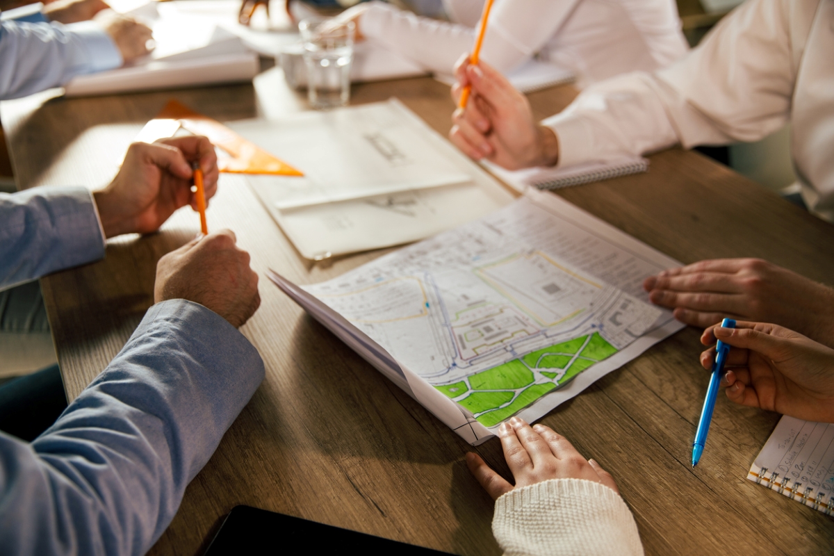 Group of people looking at property map.