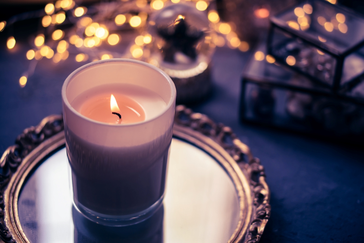 Lit candle on candle tray.