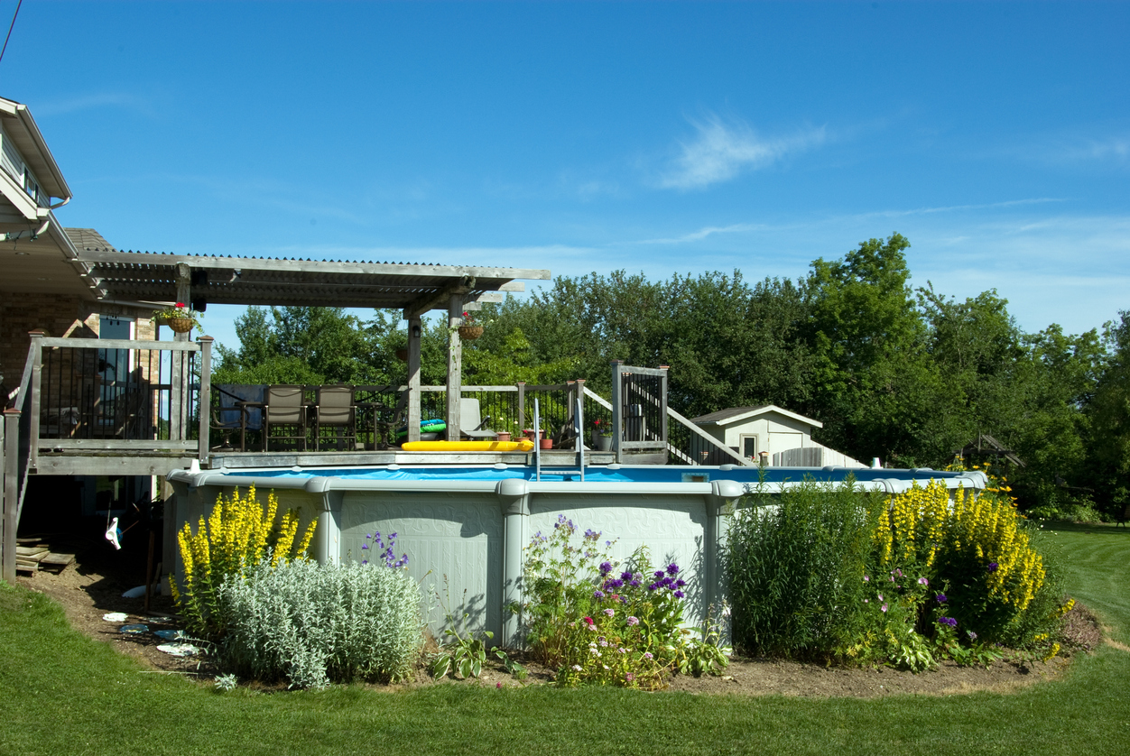 Une terrasse et une piscine hors sol dans l'arrière-cour.