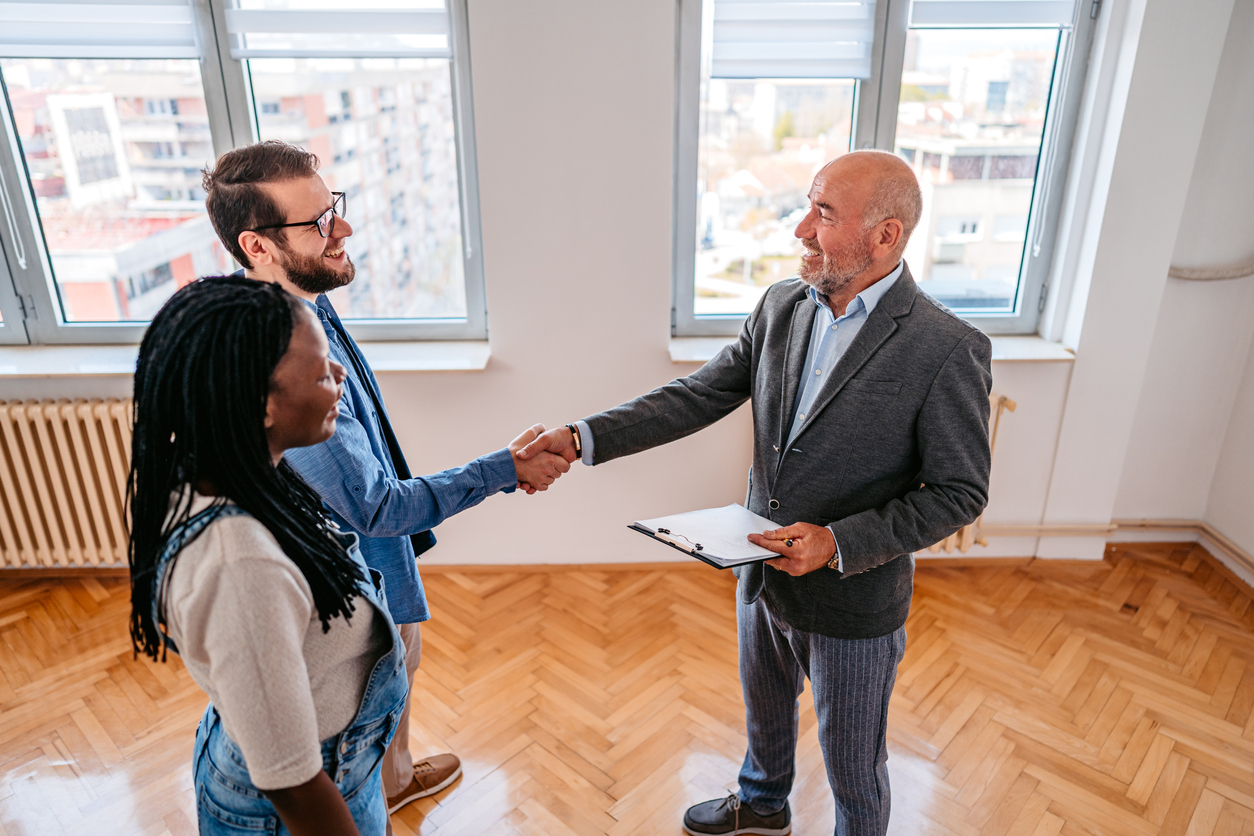 landlord talking to couple renting an apartment