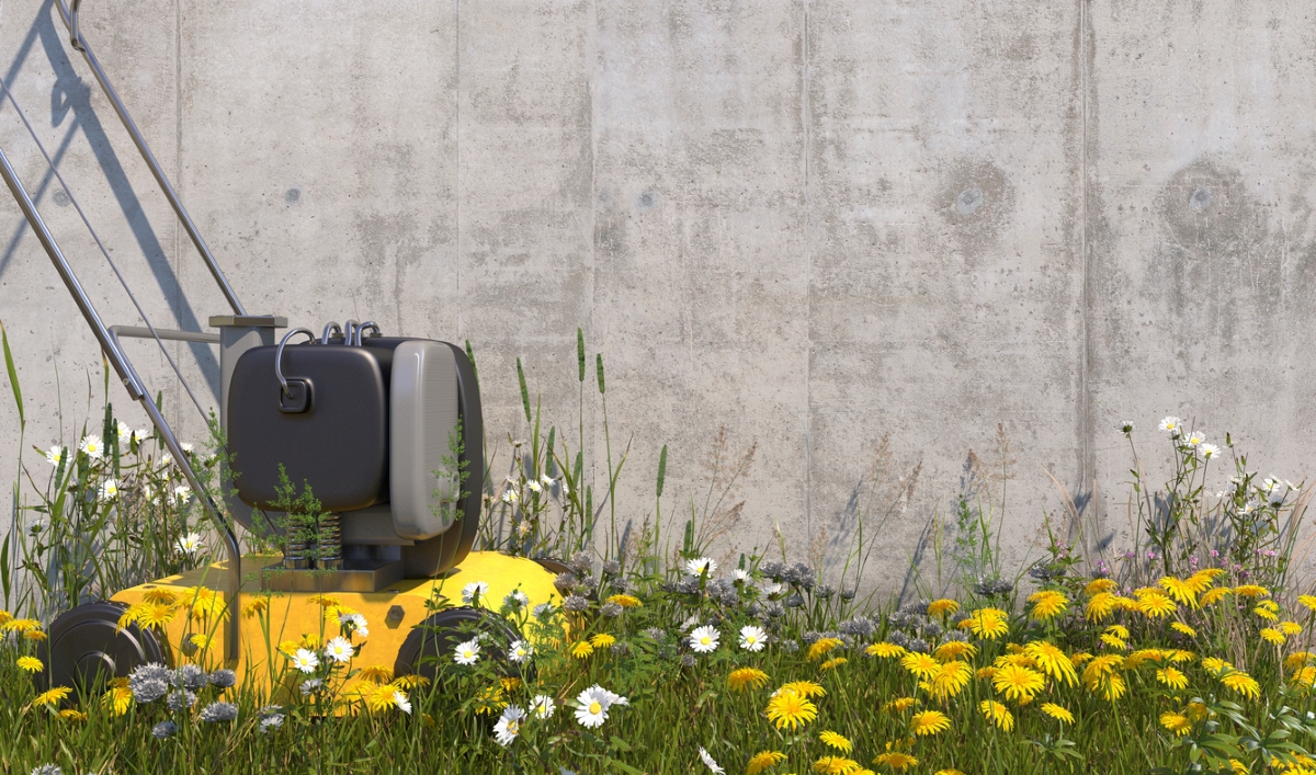 A yellow lawn mower surrounded by native flowers.