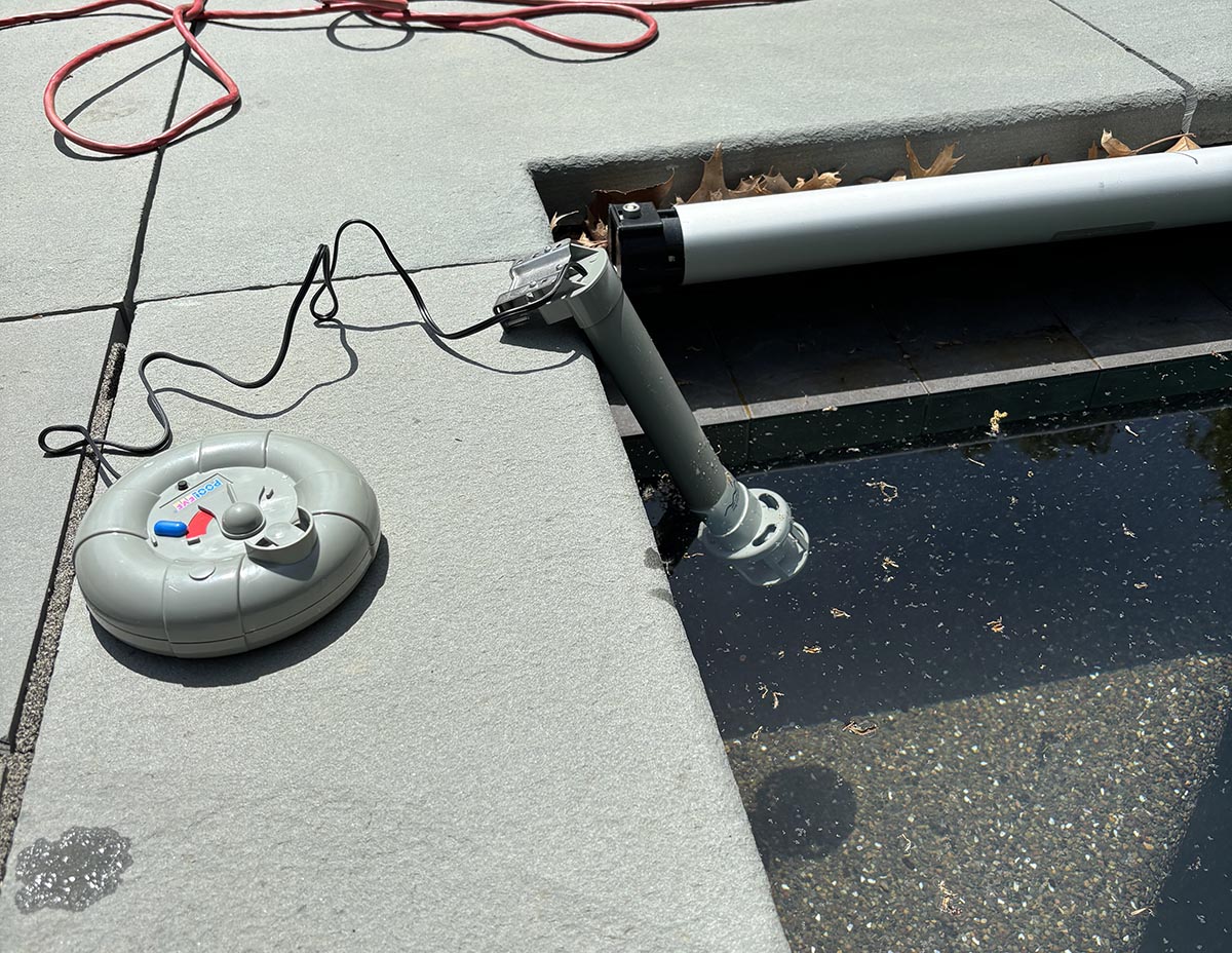 The PoolEye Above-Ground Pool Alarm on a pool deck and floating in a pool.