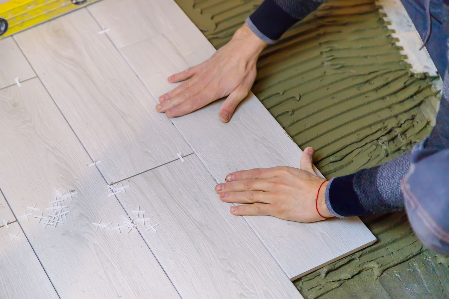 Expert Craftsman Installing Engineered Wood Floor in a Residential Home, Highlighting the Texture and Quality of the Material.