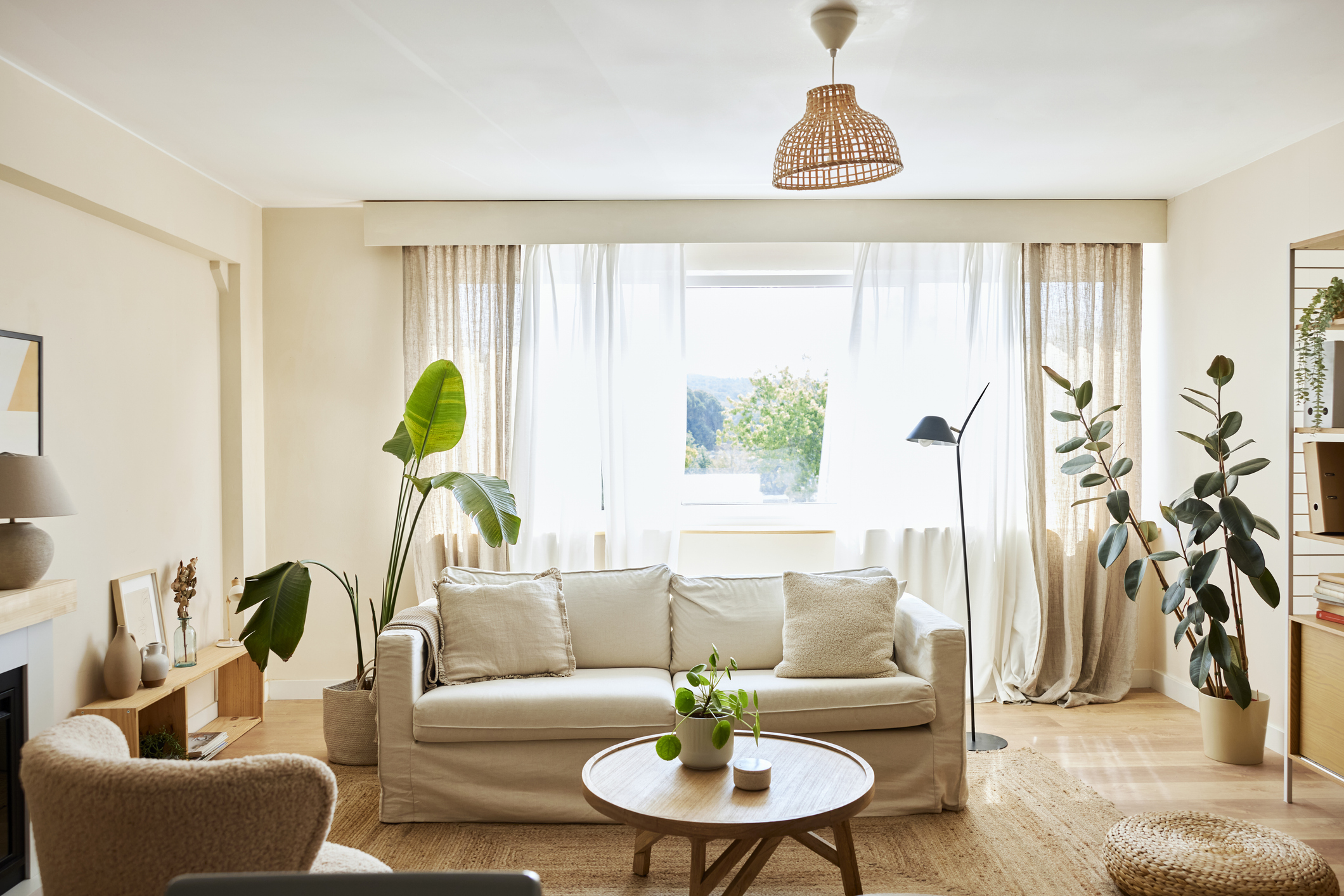 A cream couch sits in the center of a bright living room.