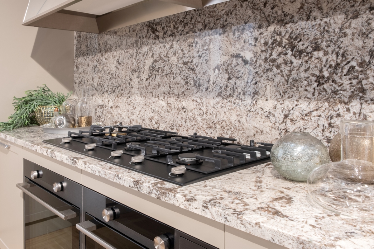 Kitchen with speckled granite walls and countertops around stove.