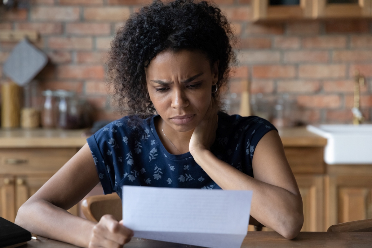 Young woman looking at letter with frown