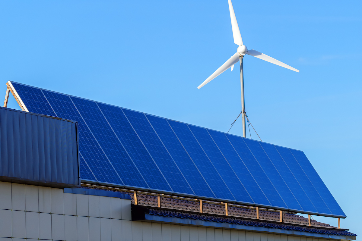 home wind turbine mounted on roof with solar panels