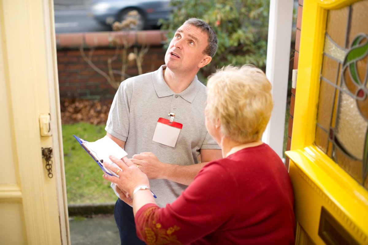 Elderly woman surprised by male guest with clipboard