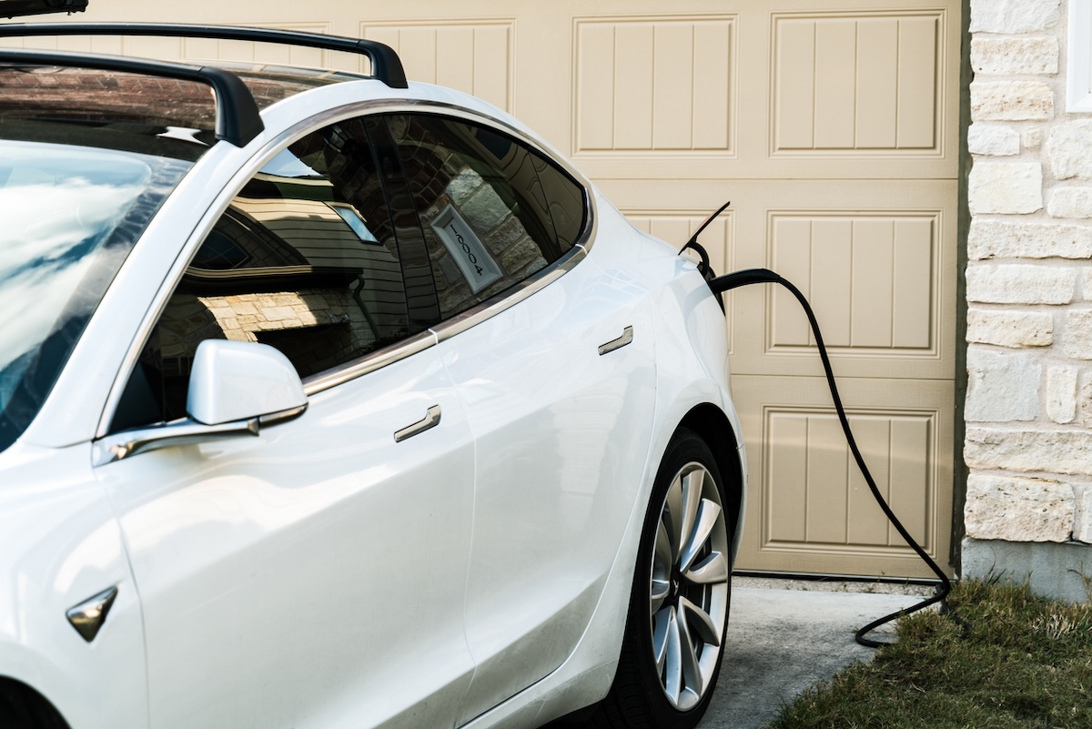 An electric vehicle charging in a home driveway.