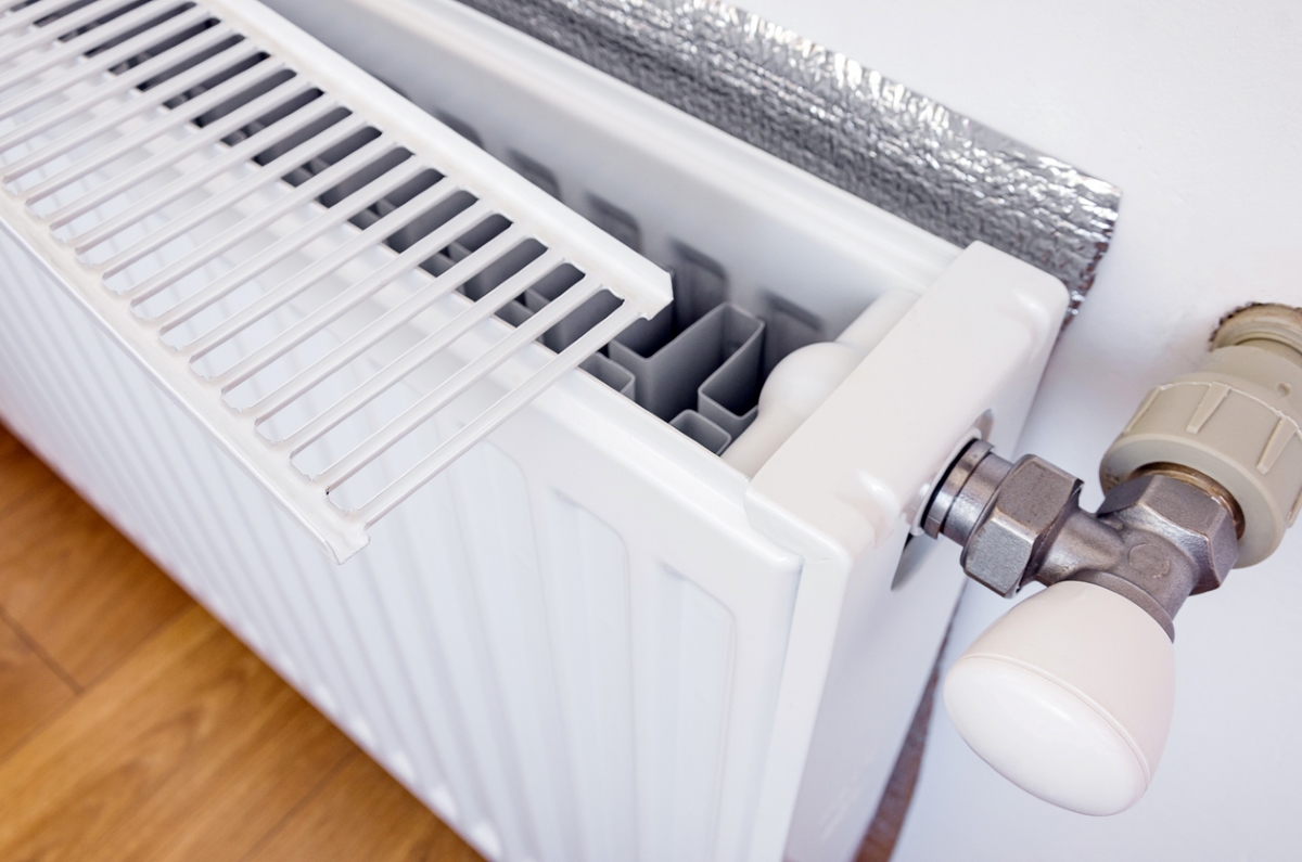 Radiator with grill removed and foil behind it.