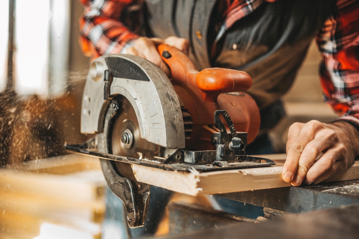 les outils électriques les plus dangereux - un homme utilisant une scie circulaire à portée de main