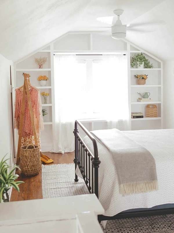 interior view of a bedroom with a bed, bookshelf, and ceiling fan