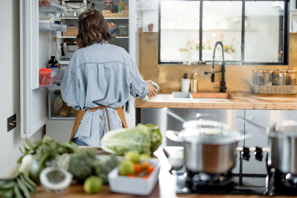 dirty kitchen - woman looking into fridge