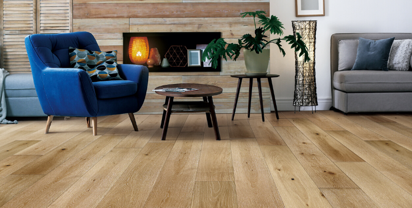 living room with engineered flooring, blue chair, coffee table, and fireplace