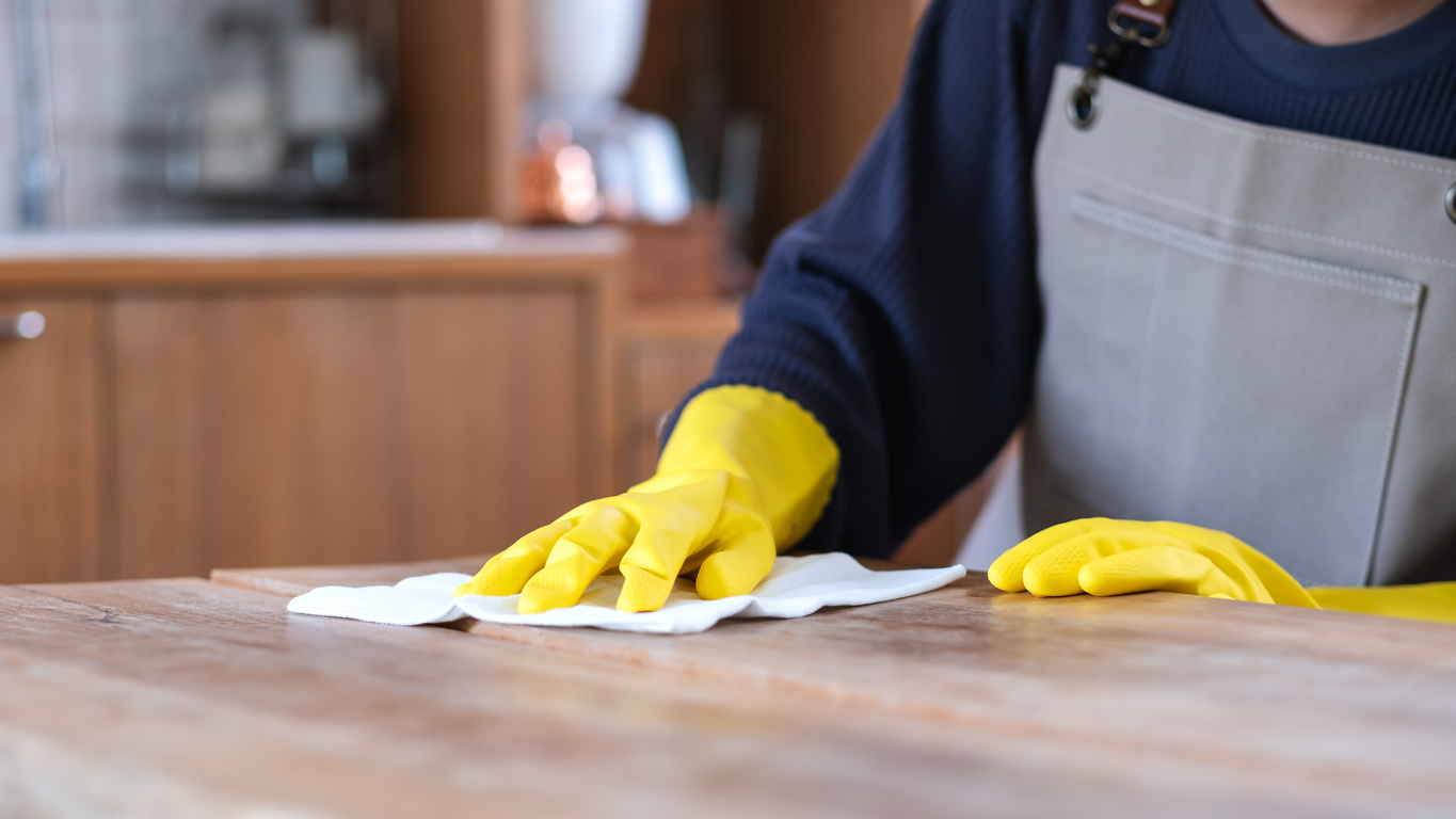 butcher block countertops gloved hands wiping countertop with soft cloth