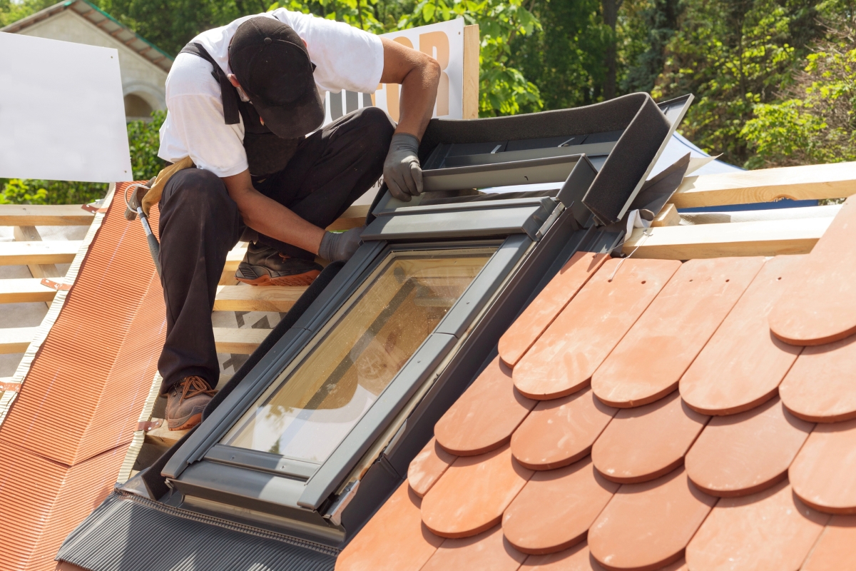 The roofer is finishing the install on a skylight.