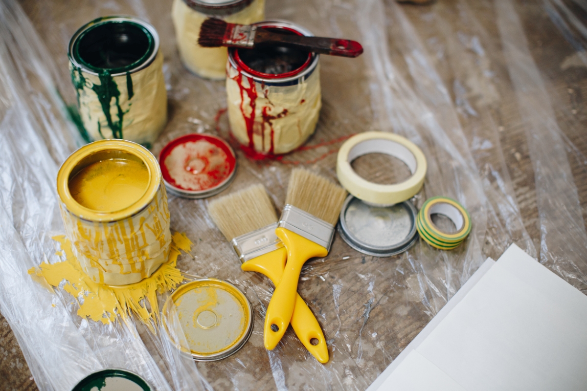 Painters tape wrapped around open paint cans.