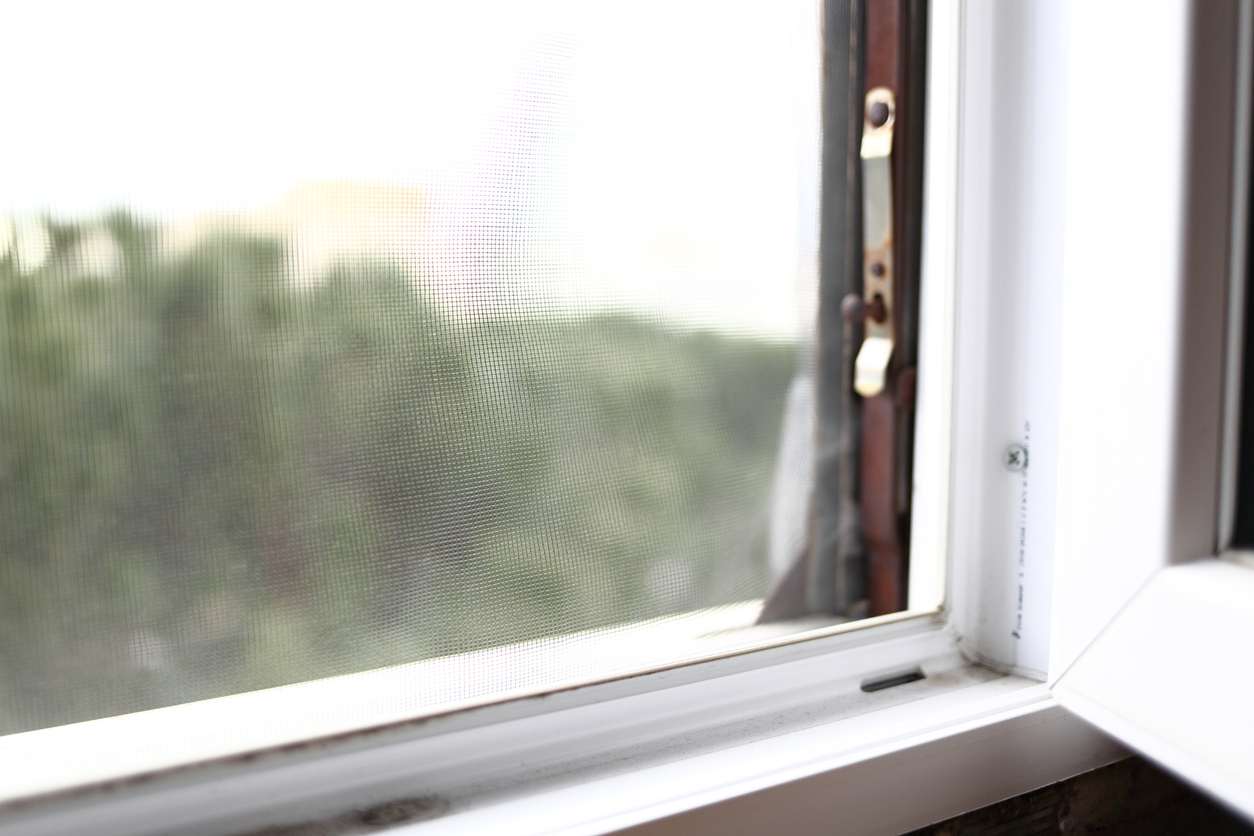 close view of open window with view of trees and hills outside