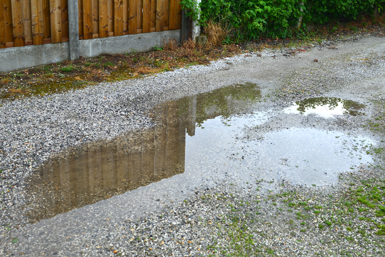 grande flaque d'eau dans l'allée de gravier