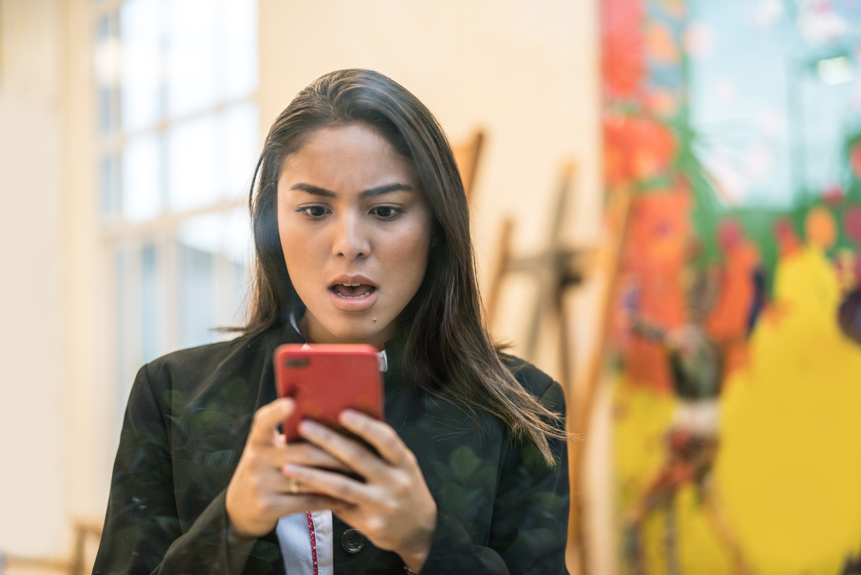 young woman upset looking at mobile phone