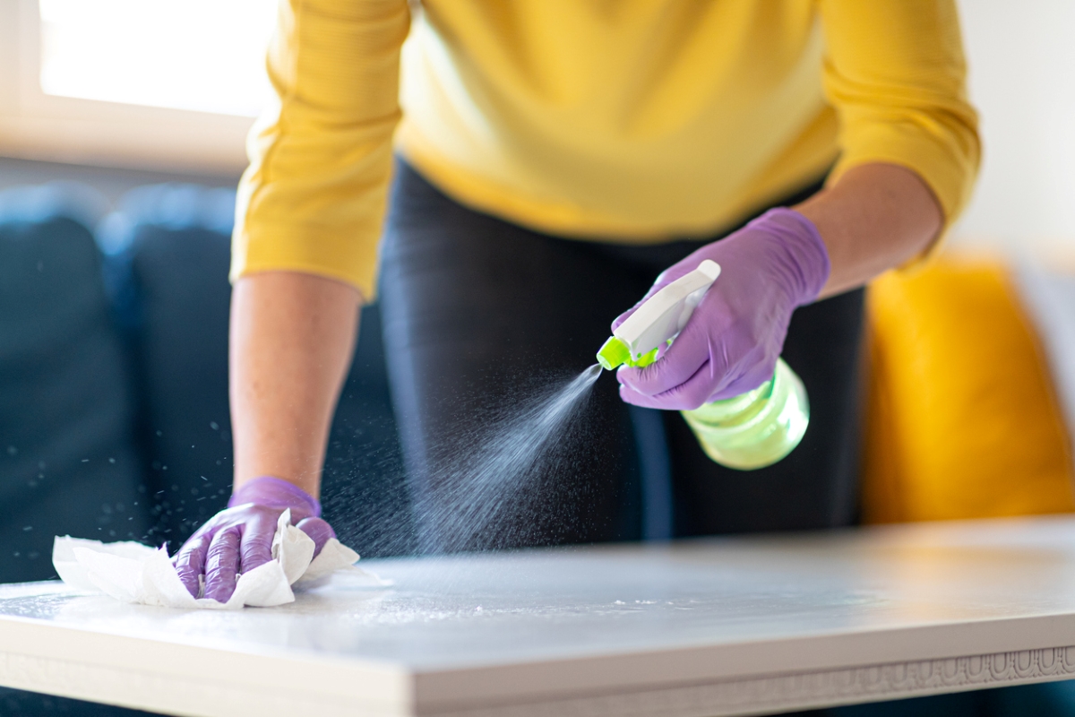 personne nettoyant le plateau de la table