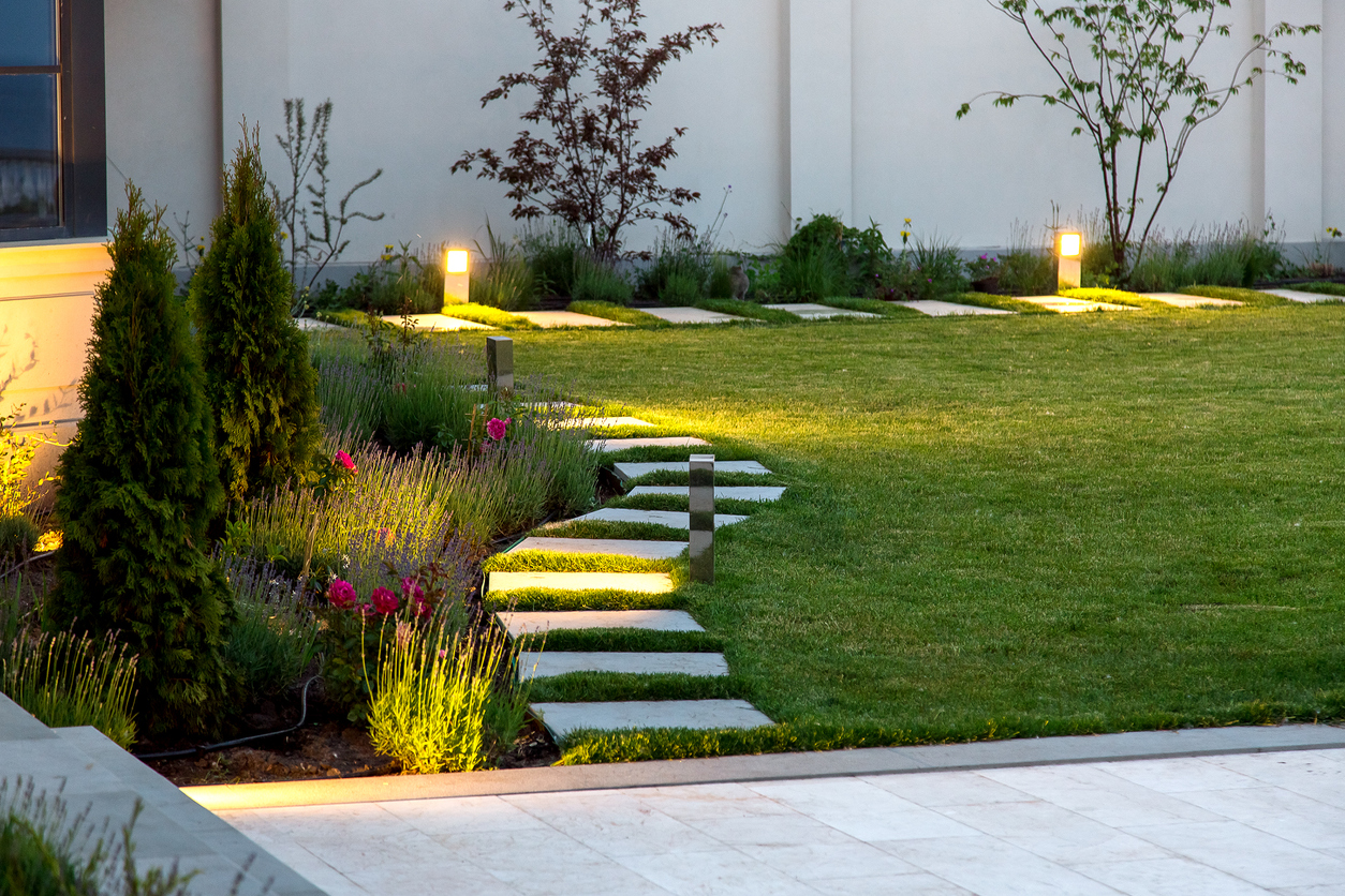 Un jardin en herbe avec une allée en pierre.