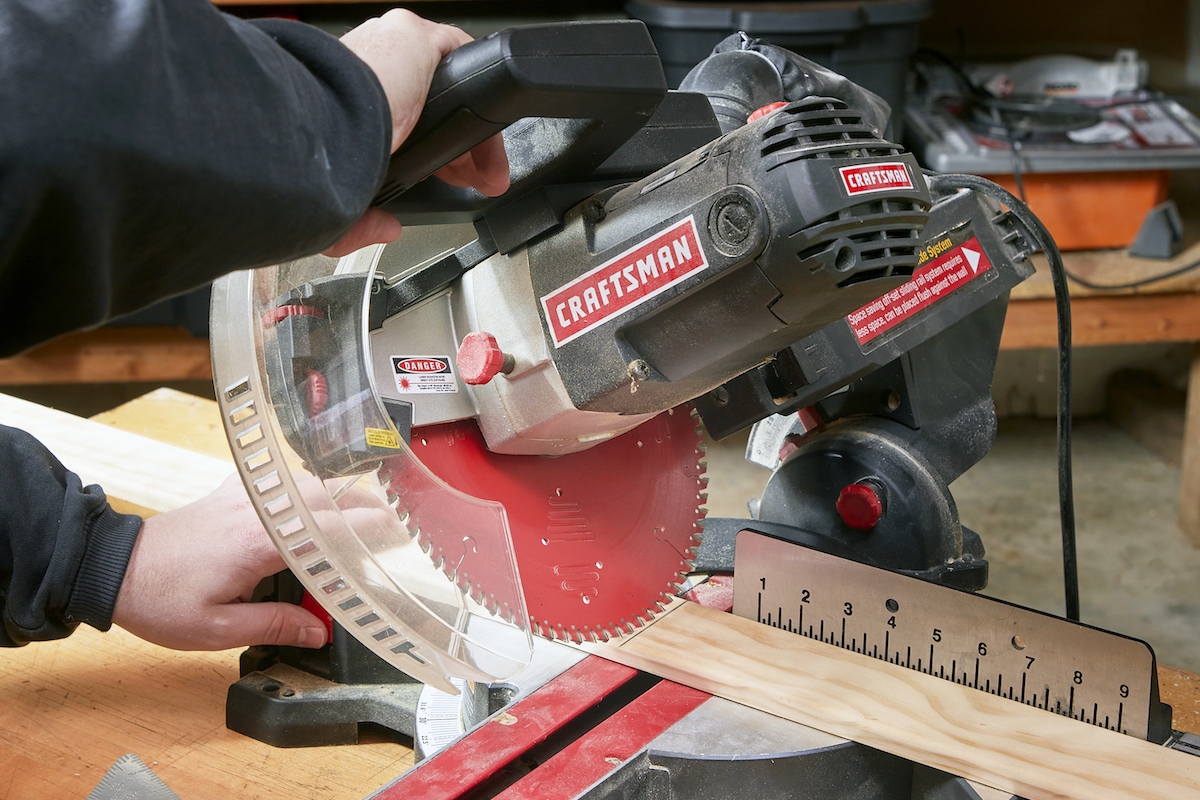 Making sure the fence is clear on a miter saw.