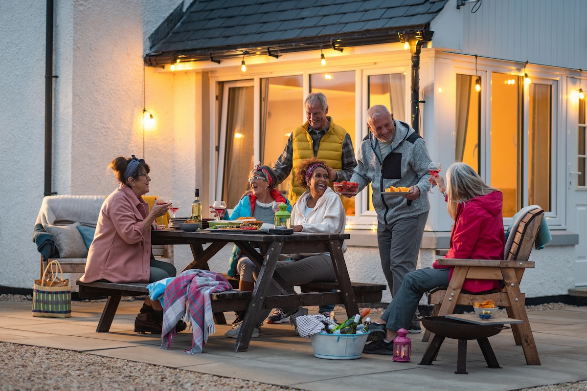 Friends and neighbors spending time on a patio in fall.