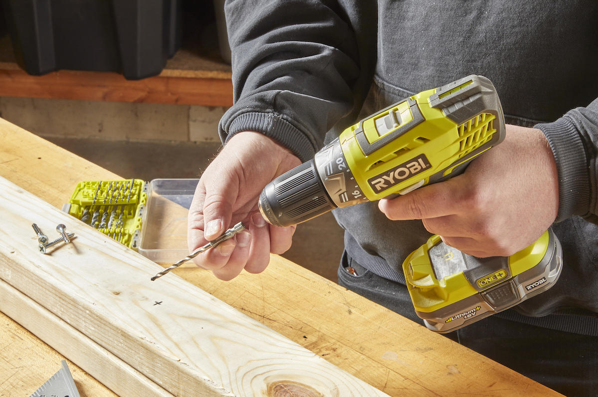 Man fits a drill bit into a drill.