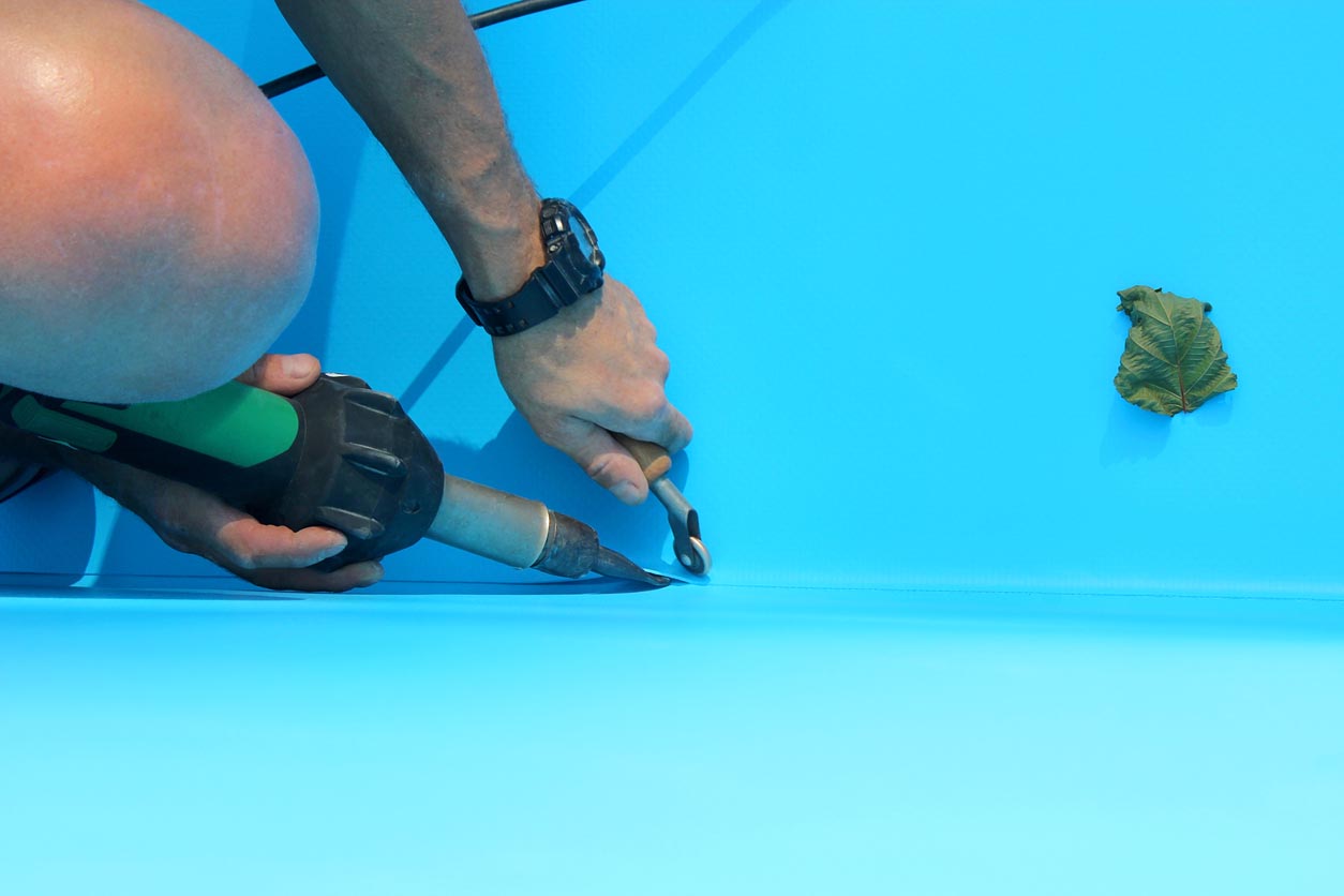 A worker replaces a pool liner.