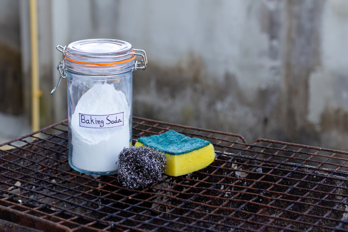 Baking soda with sponge and steel wool on rusted grill.