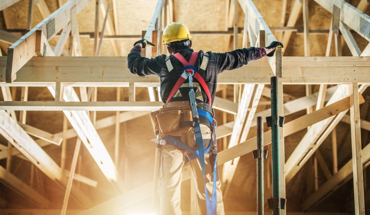 A construction worker does work in a home under construction.