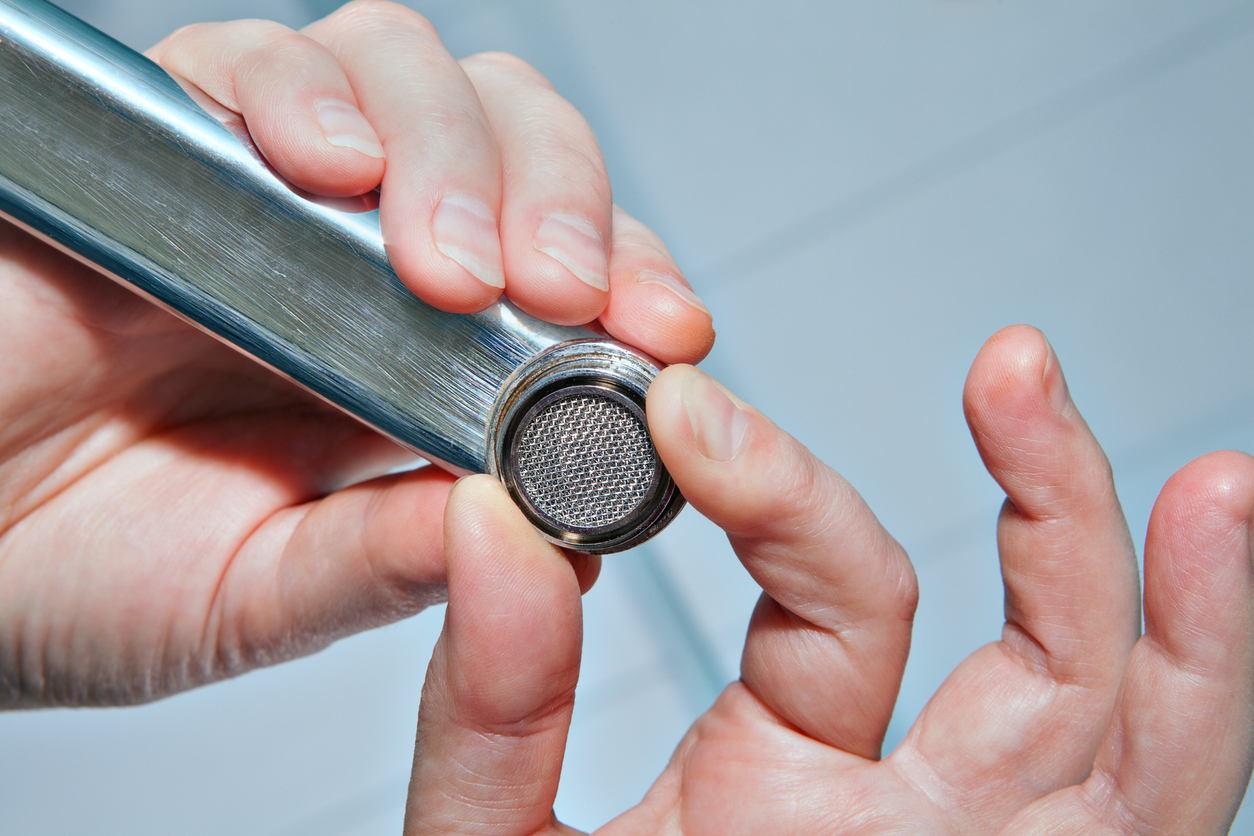 Close view of hand holding faucet aerator