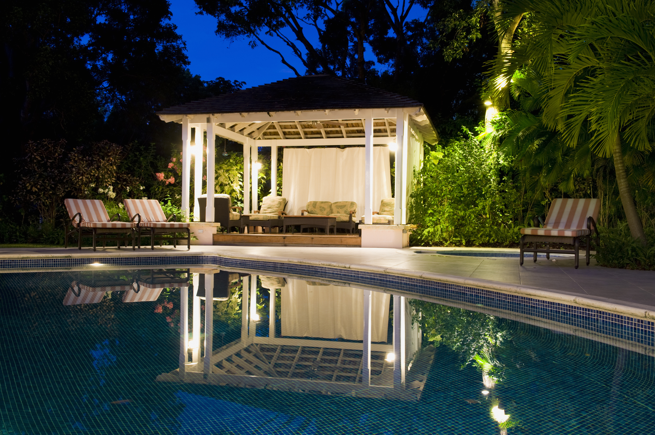 Le cabanon blanc et crème dans une piscine de jardin.