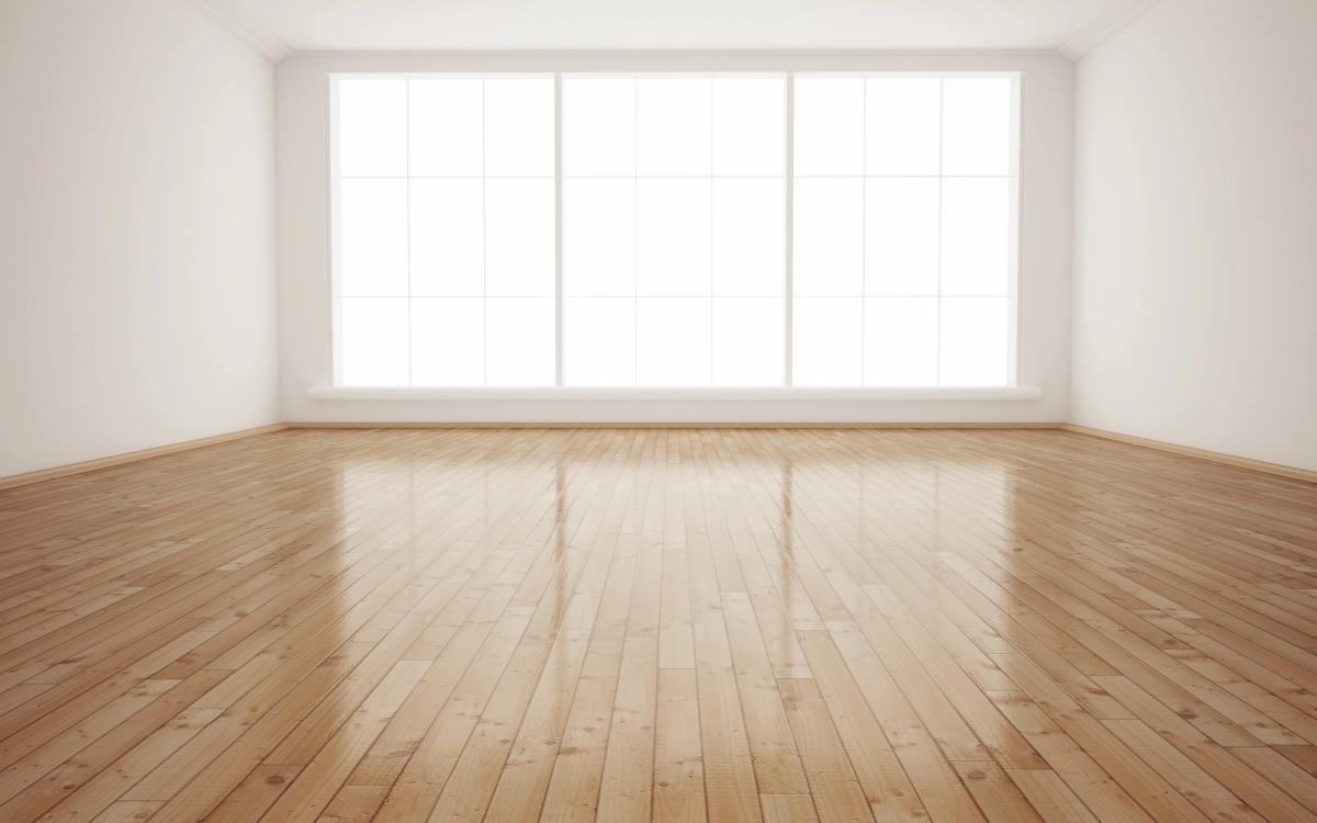 An empty plain room with wooden floors.