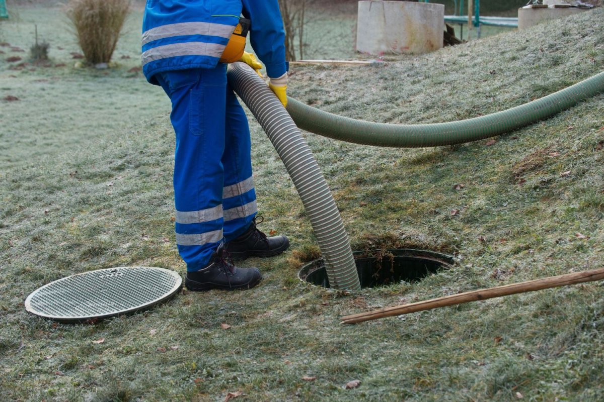 Un ouvrier abaisse un tuyau dans un pipeline dans une cour. 