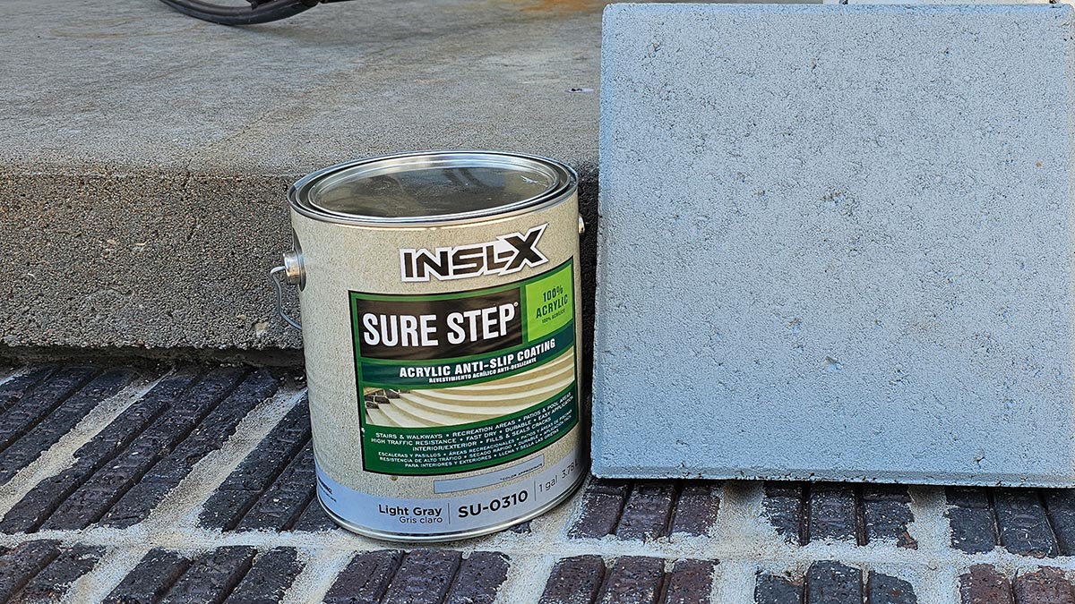 A can of INSL-X Sure Step Acrylic Anti-Slip Paint next to a cement paver before testing.