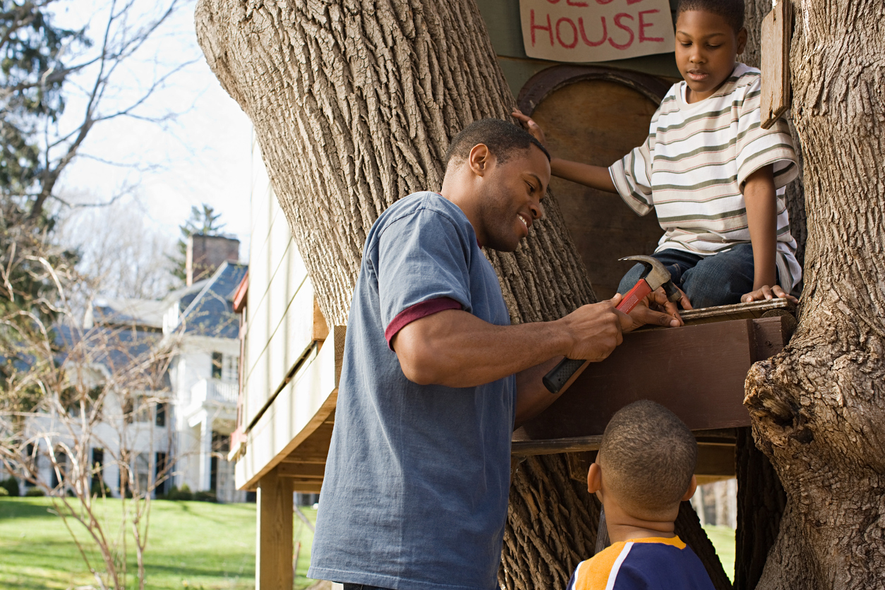 Father and sons building tree house