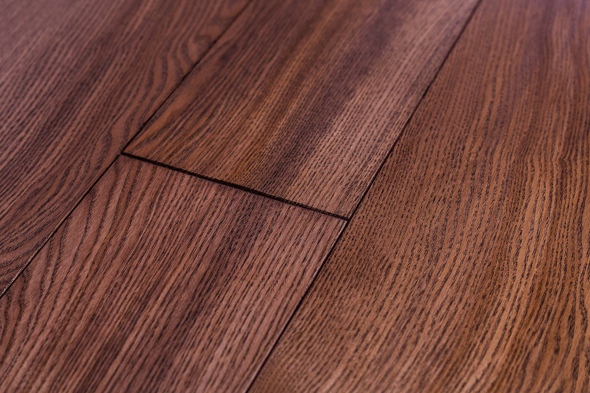 Dark faux wood laminate flooring with a visible gap running between two planks.