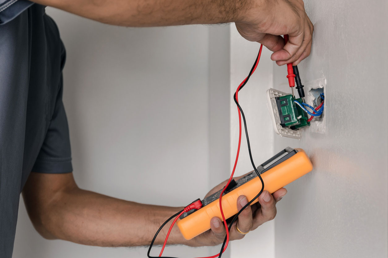 A worker tests a GFCI outlet. 