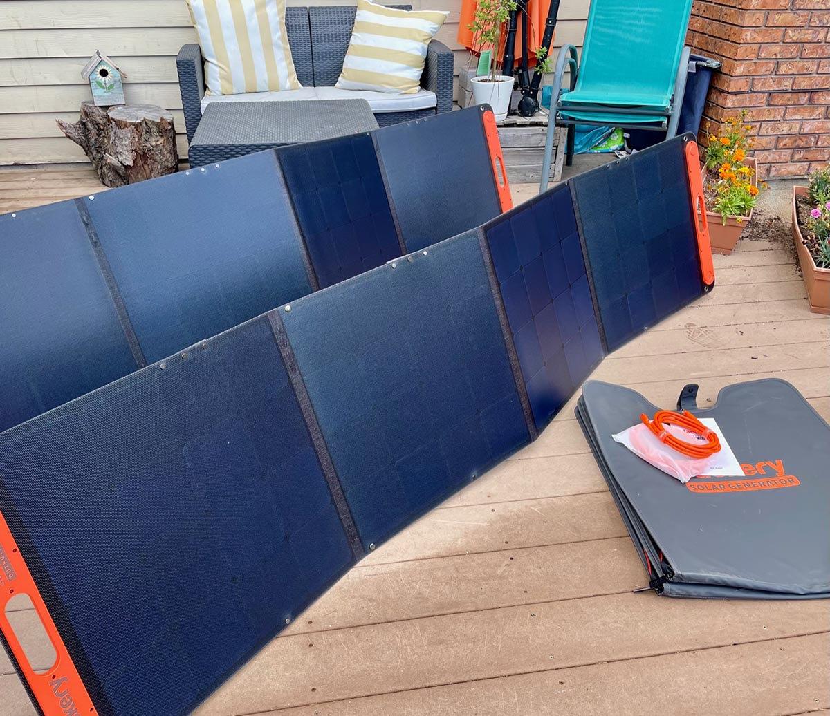 Les panneaux solaires du générateur Jackery 3000 Pro Solar Generator sont installés sur une terrasse à côté de leurs sacs de transport.