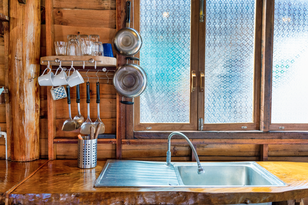 iStock-1275783607 ways to dress up a window Wood paneling kitchen with stainless steel sink and utensils