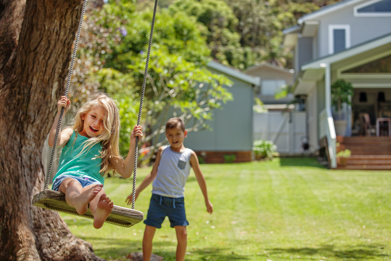 Brother and sister take turns swinging each other on their tree swing.