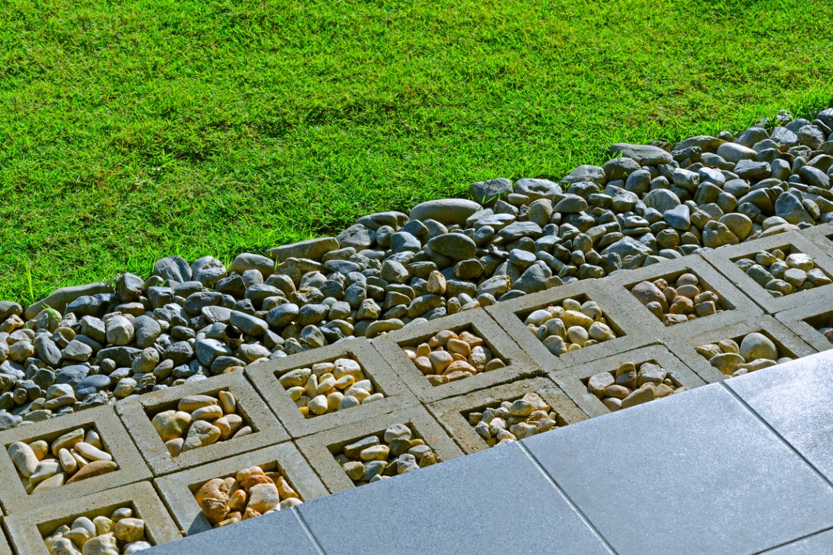 Le sol du jardin est agrémenté d'herbe verte, de gravier et complète le relief.