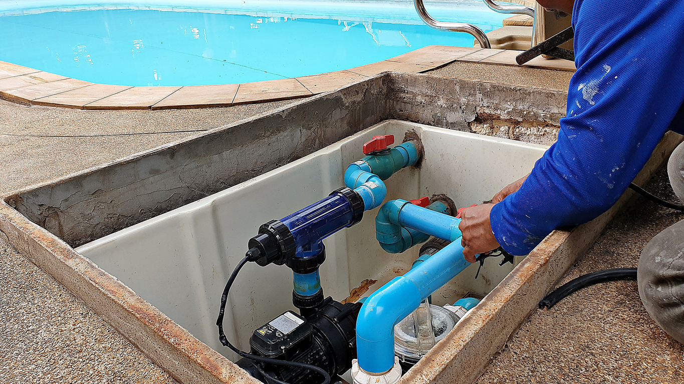 Technician fixing swimming pool water pump for saltwater pool.