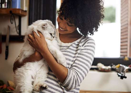 Woman holding cat in laundry room