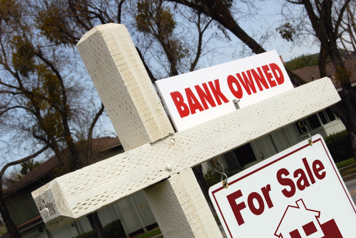 A close up of a 'bank-owned for sale' sign.