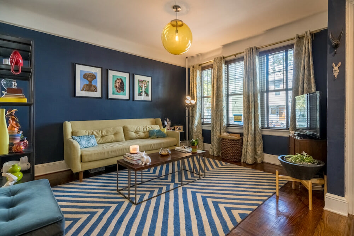 Blue living room with multiple panel windows and curtains