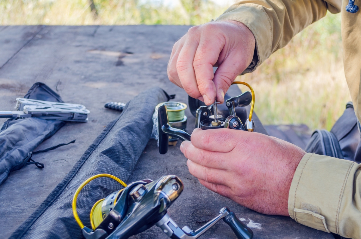 Person repairing and cleaning fishing tools.