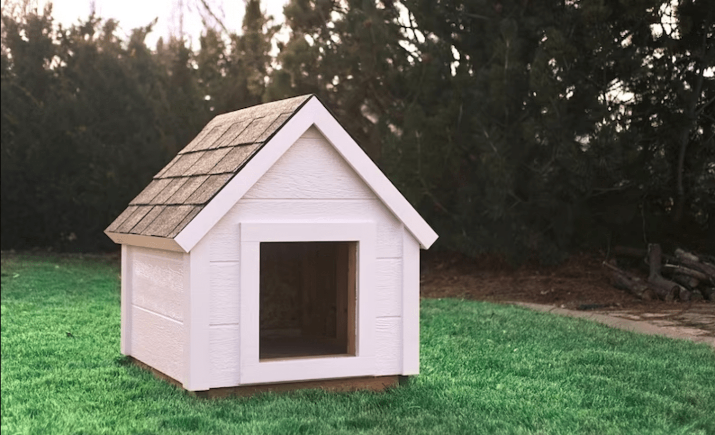 niche classique avec toit triangulaire en bois blanc dans une cour avec gazon vert